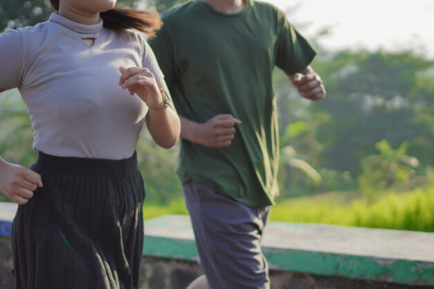 young asian couple in sporty clothes running together in the morning
